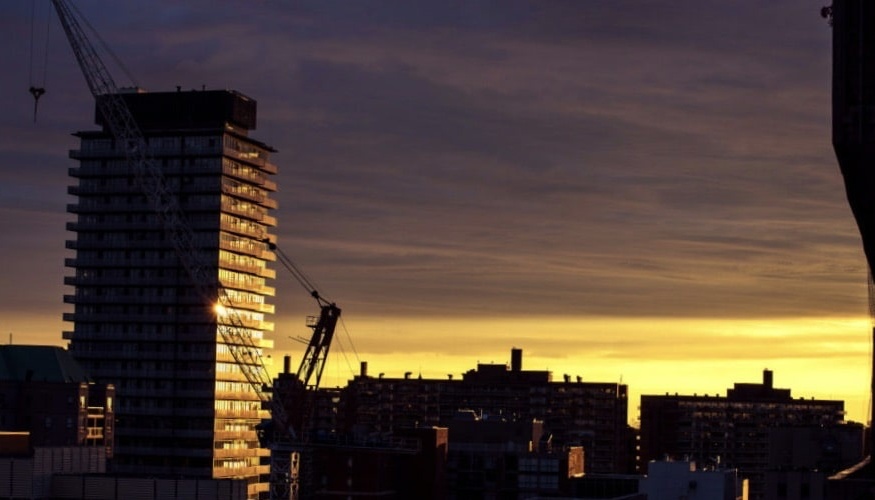 Baustelle Hochhaus im Sonnenuntergang mit Baukran 